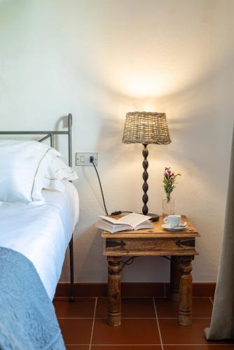 a lamp on a table next to a bed at La Muccheria in San Vincenzo