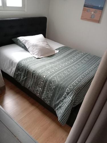 - un lit avec une tête de lit noire et un oreiller dans l'établissement Mobil home 6 pers - camping Les Arbouses - clim terrasse plancha, au Castellet