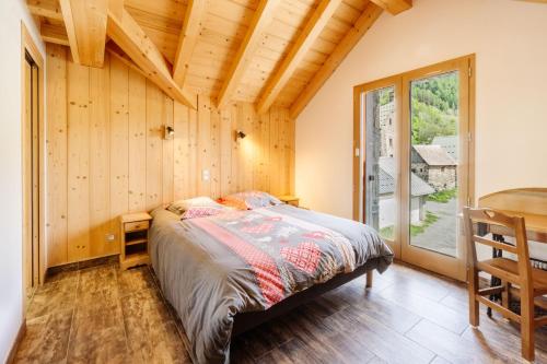 1 dormitorio con 1 cama en una habitación con paredes de madera en Lamartine, en Valloire