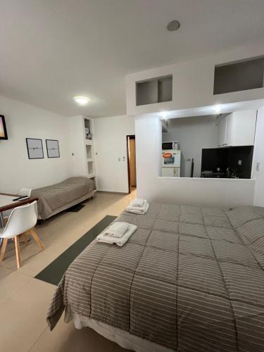 une chambre avec un grand lit avec deux serviettes dessus dans l'établissement DERC Temporarios, à Río Cuarto