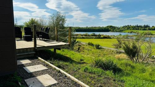 a deck with chairs and a view of a lake at Couston Lakes Resorts in Bathgate