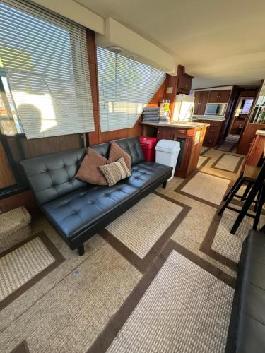a black leather couch in a living room at 60ft Stationary House Boat in New Baltimore