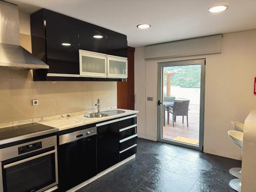 a kitchen with a sink and a stove at Casa da Recosta Douro Country House in Resende