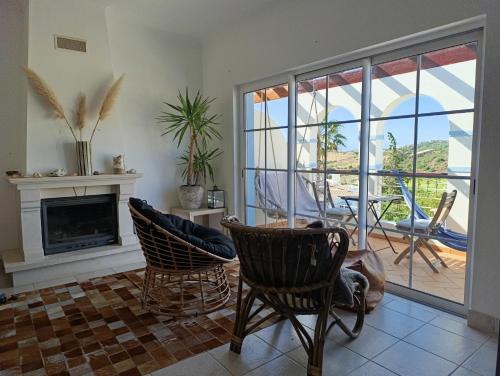 a living room with two chairs and a fireplace at Komfortables Town House in traumhafter Lage in Budens