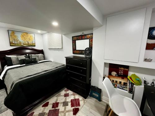 a bedroom with a bed and a desk and a chair at Brand new single unit guest basement apartment in Mississauga
