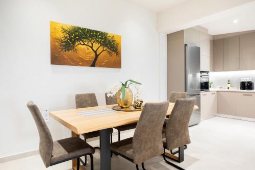 a kitchen and dining room with a wooden table and chairs at THEA Seaview Luxury Living in Kalamata