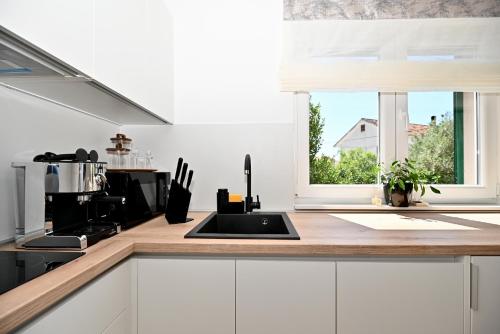 a kitchen with a sink and a window at Kinda Residence in Bibinje