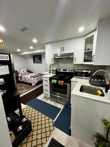 a kitchen with white cabinets and a sink at Brand new single unit guest basement apartment in Mississauga