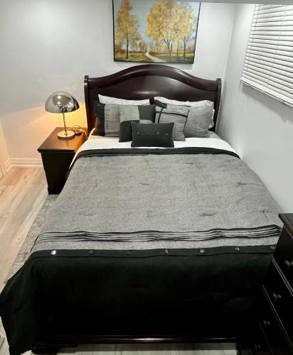 a bedroom with a large bed with a laptop on it at Brand new single unit guest basement apartment in Mississauga