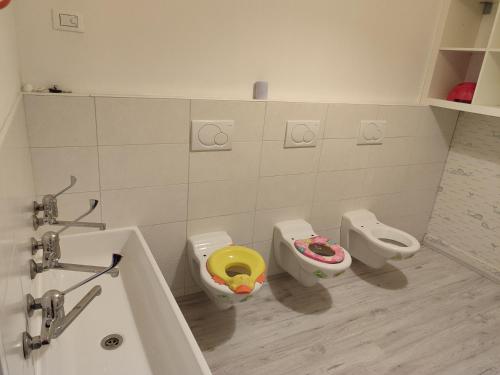 a bathroom with two toilets and a tub and two urinals at Al Nido in Pietramurata