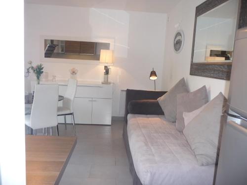 un salon avec un canapé blanc et une cuisine dans l'établissement Liyaroyce, à Cavalaire-sur-Mer