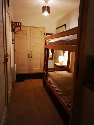 une chambre avec deux lits superposés et un placard dans l'établissement Chamonix, studio de 24 m2, à Chamonix-Mont-Blanc