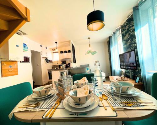 une table de salle à manger avec des assiettes et des plats dessus dans l'établissement Giulia House Fécamp - Seaside - Four Stars, à Fécamp