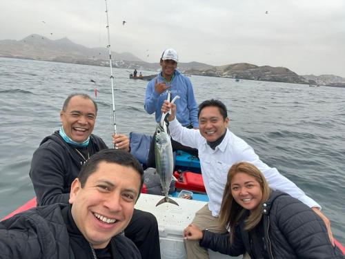 a group of people on a boat with a fish at Cruz del Sur in Pucusana