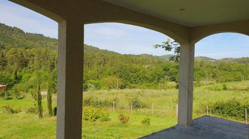 a porch with a view of a field and trees at Le Gîte de Berignac in Antugnac