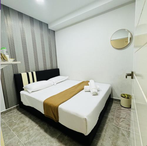 een hotelkamer met een bed en een spiegel bij Rayyaz Inn in Kuala Terengganu