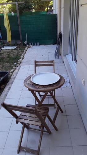 une table en bois et une chaise sur la terrasse dans l'établissement Appartement cosy, à Marseille