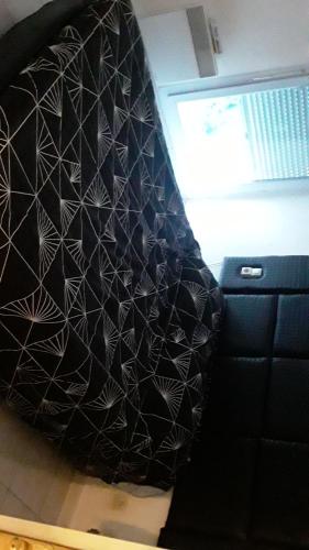 une couverture noire et blanche suspendue sur un mur dans l'établissement Appartement cosy, à Marseille