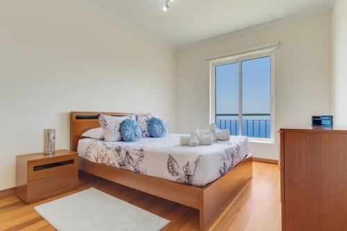 una camera da letto con un letto con una grande finestra di Sunset Horizon by Atlantic Holiday a Estreito de Câmara de Lobos