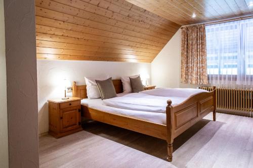 a bedroom with a large bed with a wooden ceiling at Hotel Hofgut Sternen in Breitnau