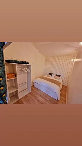 Cette petite chambre comprend un lit et une étagère. dans l'établissement Studio coeur Centre ville Troyes, à Troyes