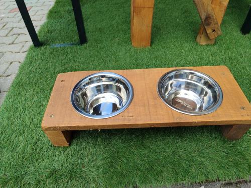 two stainless steel bowls in a wooden dog bowl feeder at Al Nido in Pietramurata