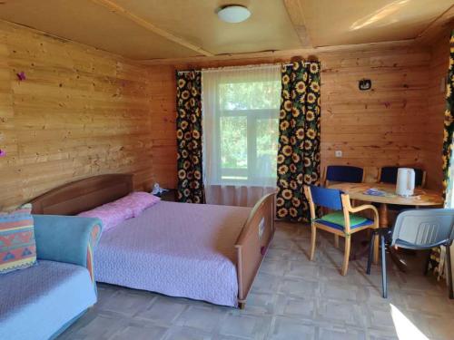 a bedroom with a bed and a table and chairs at Pie Ventas in Ventspils