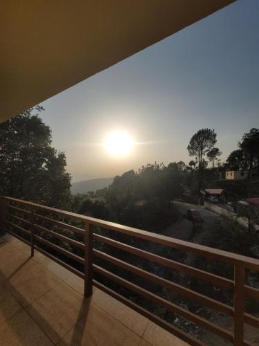 a view of the sunset from the balcony of a house at 11 Gaon Homestay Lansdowne in Lansdowne