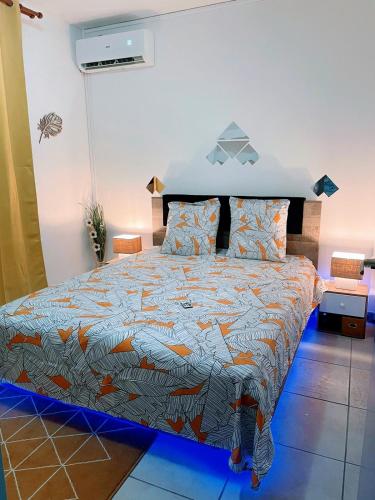 a bedroom with a large bed with a colorful comforter at TROPIK'APPART 972 in Basse-Pointe