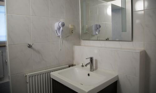 ein Badezimmer mit einem Waschbecken und einem Telefon an der Wand in der Unterkunft Hotel Eschborner Hof in Frankfurt am Main