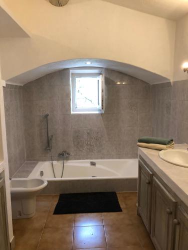 une salle de bain avec une baignoire et un lavabo dans l'établissement L'Atelier de la Baronnie - Lubéron, à Cabrières-dʼAvignon