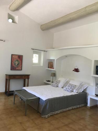 a bedroom with a bed and a table in it at L'Atelier de la Baronnie - Lubéron in Cabrières-dʼAvignon