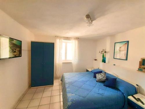 a bedroom with a blue bed and a window at PonzaSmeralda Le Forna in Ponza