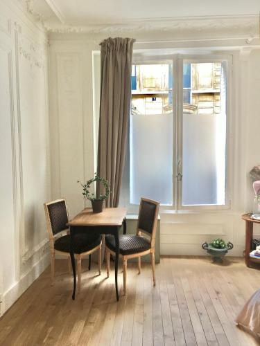 une salle à manger avec une table et des chaises et une fenêtre dans l'établissement Lovely Parisian Studio Condorcet, à Paris