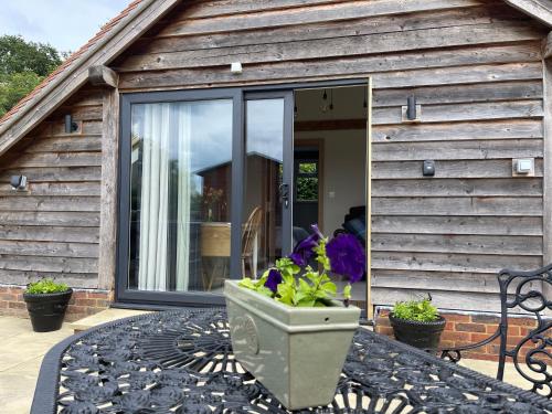 una casa con un vaso di fiori sul portico anteriore di Lancasters Cottage a Horsham