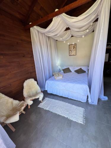 a bedroom with a bed with a canopy at Recanto dos Pássaros in Alto Caparao