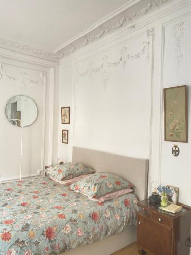 une chambre avec un lit, une commode et un miroir dans l'établissement Lovely Parisian Studio Condorcet, à Paris