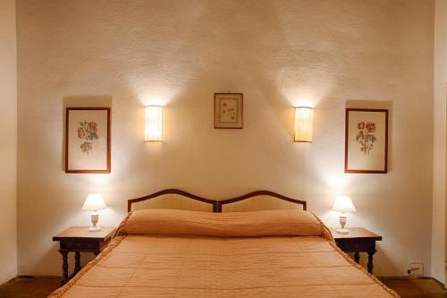 a bedroom with a large bed with two lamps on the wall at Villa Rucellai in Prato