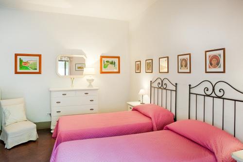 a bedroom with two beds and a dresser and a mirror at Villa Rucellai in Prato