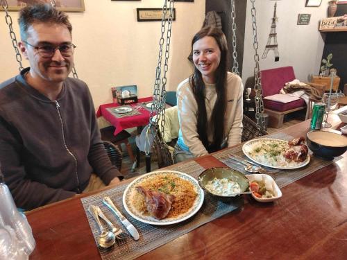 Un uomo e una donna seduti a un tavolo con del cibo di mountain view house a Kerak