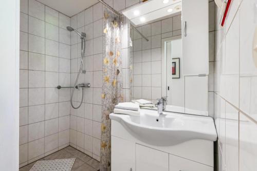 a white bathroom with a sink and a shower at Ferienwohnung Devich in Oersberg