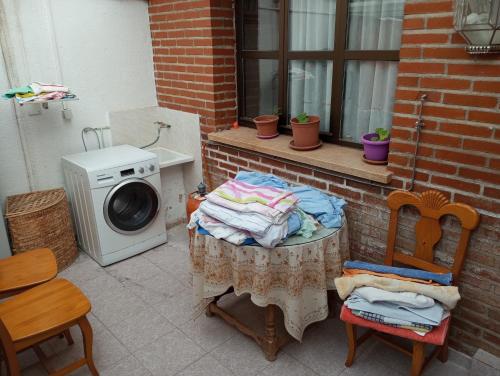 a washing machine sitting next to a table with a washing machine at Habitacion Privada Familiar Toledo in Toledo