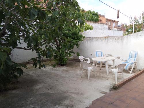 a table and chairs in a courtyard with a wall at Habitacion Privada Familiar Toledo in Toledo