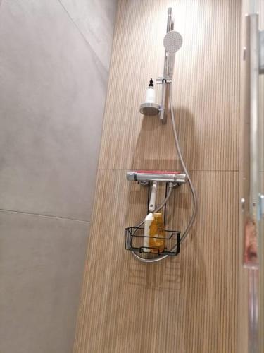 a bathroom with a shower with a basket on the wall at Charmante maison près de la mer in Asnelles