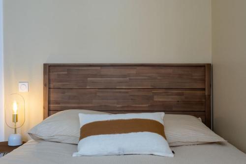 - un lit avec une grande tête de lit en bois dans une chambre dans l'établissement Le Prestigieux - Hypercentre, à Toulouse