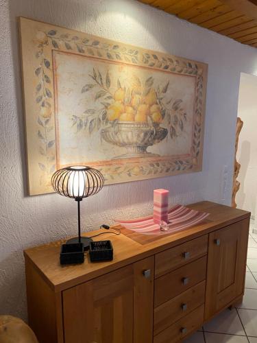a desk with a lamp and a painting on the wall at Ferienwohnung Lodge 43 in Trier