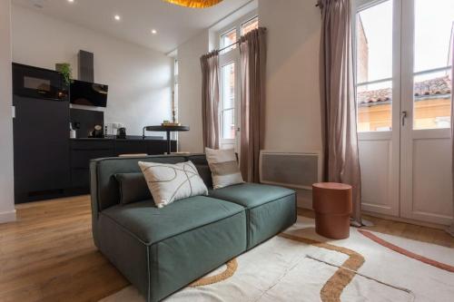 un salon avec un canapé vert et une fenêtre dans l'établissement Le Prestigieux - Hypercentre, à Toulouse