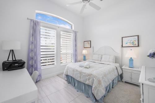 a white bedroom with a bed and a window at 1279 Balboa Court in Marco Island