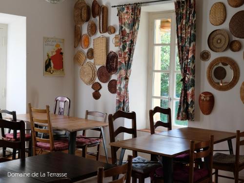 un restaurant avec des tables et des chaises en bois et une fenêtre dans l'établissement Domaine de la Terrasse, à Carbonne