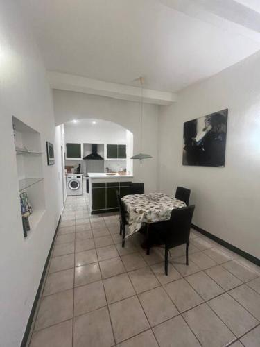 un salon avec une table et une cuisine dans l'établissement Centrale - Grand T2 Bis proche de la mer, à Nice